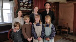 En familj i gammaldags kläder poserar för kameran